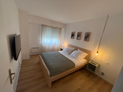 une chambre avec un lit et une télévision à écran plat dans l'établissement Appartemment Cozy Vue sur Mer, à Marseille