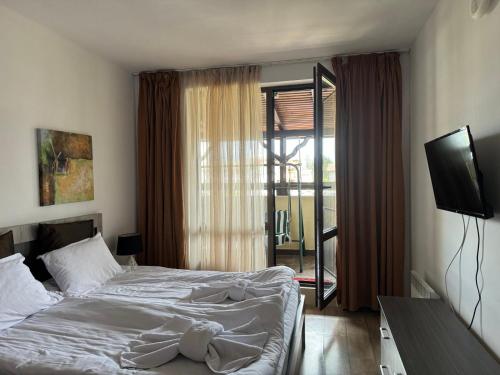 a bedroom with a bed and a television in it at Alpine Lodge Bansko Apartments in Bansko