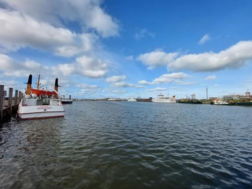 a boat is docked at a dock in the water at Pension Norddeicher Straße in Norden