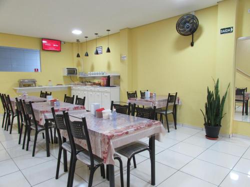 a dining room with tables and chairs in a restaurant at Hotel Biz a 8 minutos do Brás, a 15 minutos da 25 de março e a 8 minutos do Bom retiro in Sao Paulo