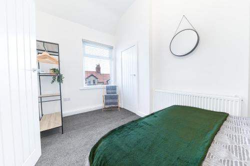 a bedroom with a green blanket on a bed at 24 Baden Powell in Barrow in Furness