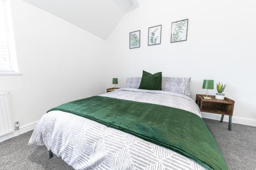 Un dormitorio blanco con una cama verde y blanca en 24 Baden Powell, en Barrow-in-Furness