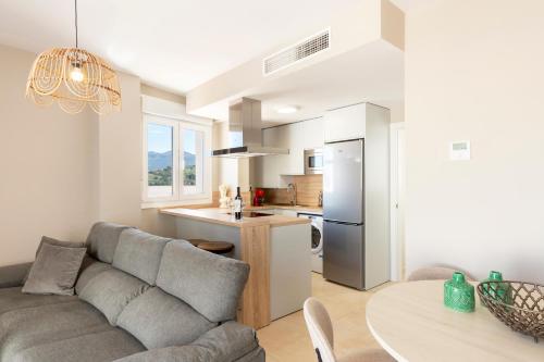 a living room and kitchen with a couch and a table at Apartamentos Martalia Áticos Deluxe in Ronda