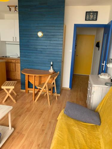ein Wohnzimmer mit Tisch und Küche in der Unterkunft Studio Saint Jean de Monts (Front de mer) in Saint-Jean-de-Monts