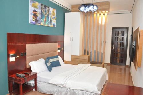 um quarto com uma cama e uma mesa com uma mesa de cabeceira em Freedom Palace Hôtel em Porto Novo