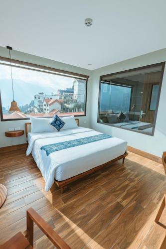 a bedroom with a large bed and a large window at Sapa Yen Hotel in Sa Pa