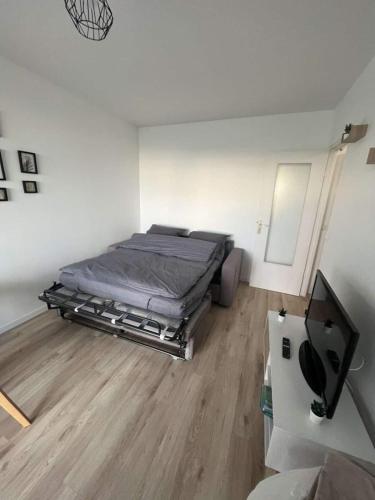 une chambre avec un lit et une télévision à écran plat dans l'établissement Un Cocon au Bord de l'Océan Vue Partielle sur Mer, à Villers-sur-Mer