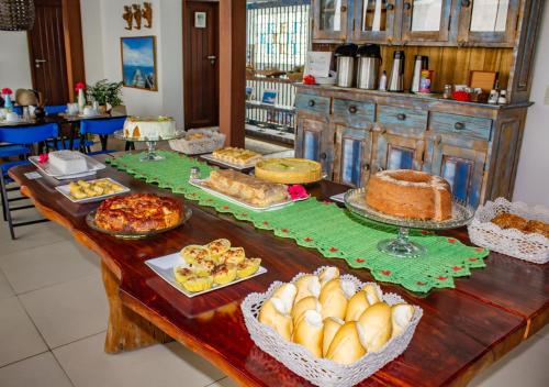 Una mesa con muchos tipos diferentes de comida sobre ella. en Pousada Bahia Inn, en Morro de São Paulo