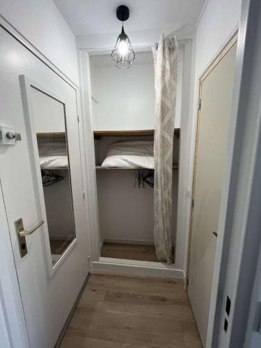 un couloir avec un placard avec un lit et un miroir dans l'établissement Un Cocon au Bord de l'Océan Vue Partielle sur Mer, à Villers-sur-Mer