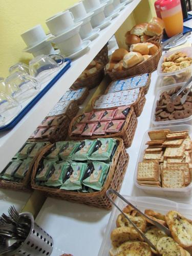 a table with many baskets of bread and pastries at Hotel Biz a 8 minutos do Brás, a 15 minutos da 25 de março e a 8 minutos do Bom retiro in Sao Paulo