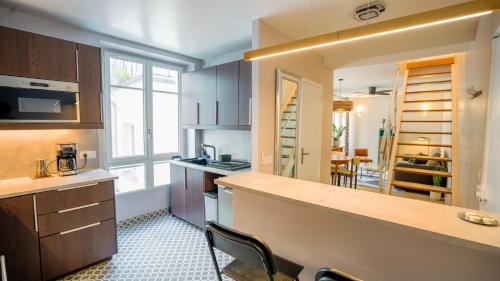 une cuisine avec des armoires en bois et un comptoir dans l'établissement Spacious Duplex Oberkampf - Bail mobilité, à Paris