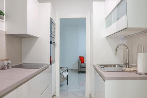 a kitchen with white cabinets and a sink at Apartment PiccoBello in Dubrovnik