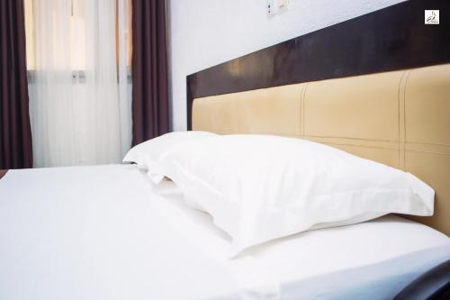 two white pillows sitting on top of a bed at Hotel le Pelican in Lomé