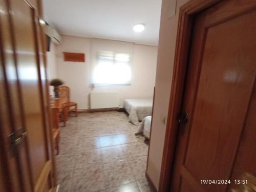 un couloir avec une chambre avec un lit et une fenêtre dans l'établissement HOTEL GRAN VIA, à Calera y Chozas