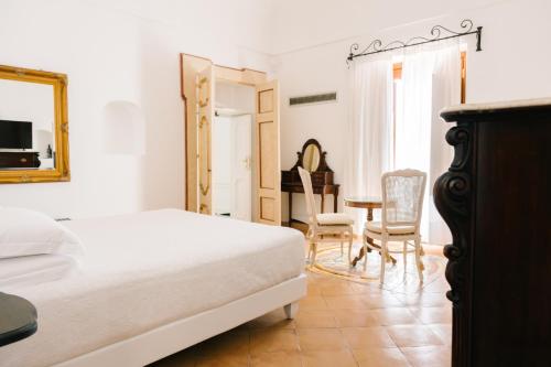 ポジターノにあるヴィラ プリンチペ ジョヴァンニのベッドルーム1室(ベッド1台、テーブル、椅子付)