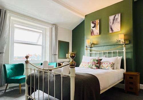 een slaapkamer met een bed en een groene muur bij The Kendrick Exclusively for adults in Llandudno