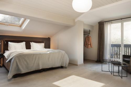 a bedroom with a large bed and a window at Hotel KÜGLERHOF in Tirolo