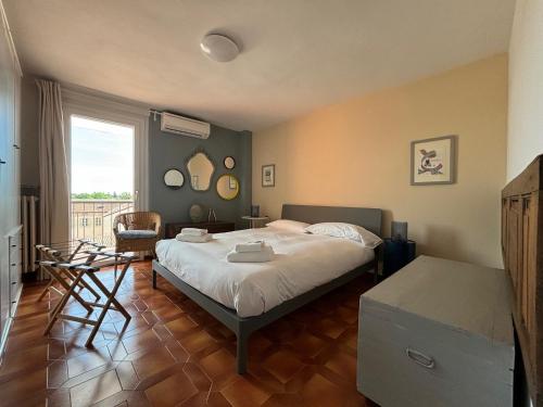 a bedroom with a bed and a chair and a window at Appartamento Tosca in Verona