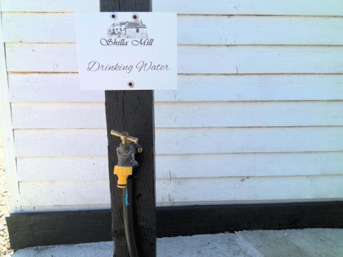 a sign on a wooden pole with a fire hydrant at Shilla Mill Camping - Grass Pitches only in Wadebridge