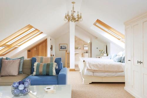 a bedroom with a bed and a blue couch at Ludbrook Manor in Ivybridge