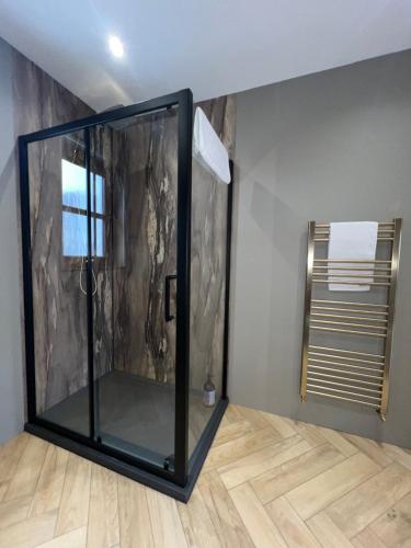 a glass shower in a room with a wooden floor at Nevis Croft Apartment 3 in Fort William