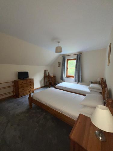 a bedroom with three beds and a window at Nevis Croft Apartment 3 in Fort William