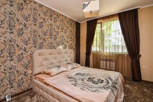 een slaapkamer met een bed en een raam bij Двустаен апартамент в центъра in Varna