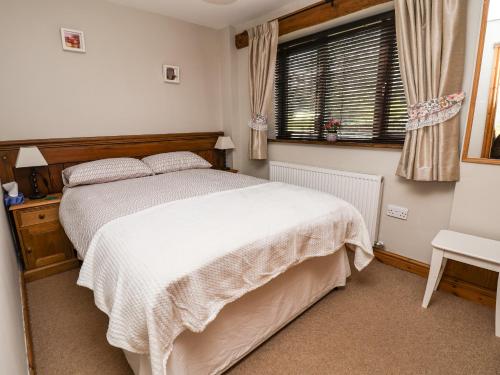 a bedroom with a white bed and a window at Dolphin Bach in Holywell