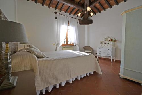 a bedroom with a bed and a dresser and a window at Casa I Pini in Cortona