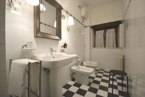 a white bathroom with a sink and a toilet at Casa I Pini in Cortona