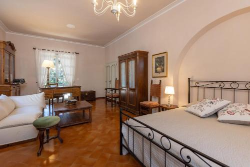 - une chambre avec un lit, un canapé et une table dans l'établissement Villa Mimosa, à Cortone