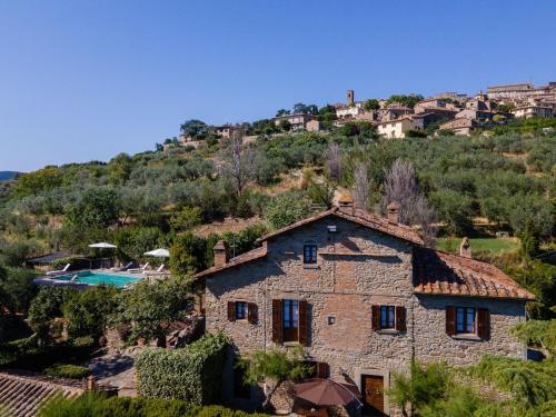 a stone house on a hill with a swimming pool at Villa I Cocciai in Cortona