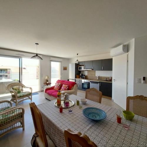 un salon avec une table et un canapé dans l'établissement Superbe T3 wifi climatisé, Le Sunset Lodge, Narbonne Plage, à Narbonne-Plage