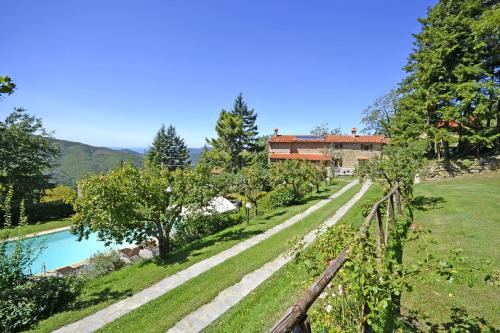 a view of a garden with a house in the background at Villa Magnolia in Cortona