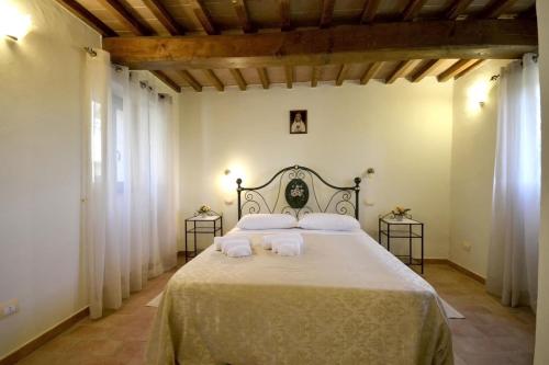 a bedroom with a large bed with white sheets and pillows at Villa Fiordaliso in Poggioni