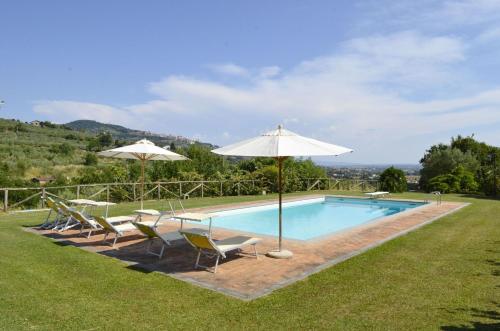 a swimming pool with chairs and umbrellas next to it at VILLA SAN PIETRO in Cortona