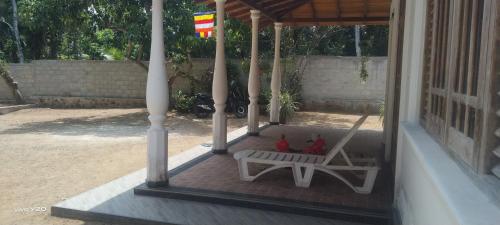 a porch with a bench and a swing at Quiet Nature Villa in Weligama