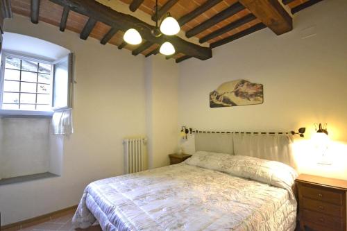 1 dormitorio con cama y ventana en Appartamento Passerini, en Cortona