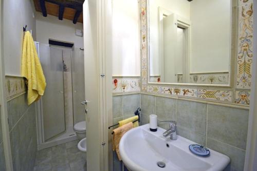 a bathroom with a sink and a toilet and a mirror at Appartamento Passerini in Cortona