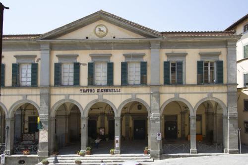 un gran edificio con arcos y un reloj en la parte superior en Cortona Suite, en Cortona