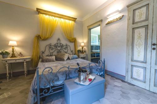 Schlafzimmer mit einem blauen Bett und einem Tisch in der Unterkunft Casa San Michelangelo in Cortona