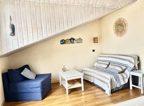 une chambre avec un lit et une chaise bleue dans l'établissement Appartement vue piscine et golf, à Talmont-Saint-Hilaire