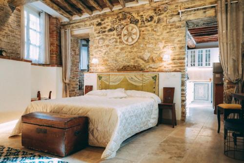 - une chambre avec un lit et un mur en briques dans l'établissement Casa San Valentino, à Cortone