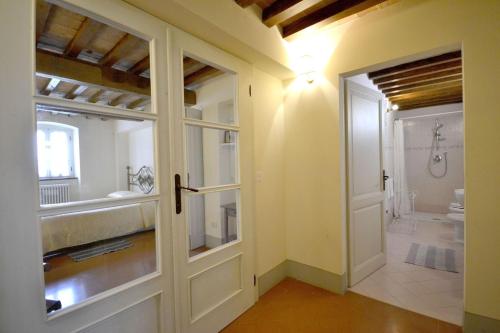 łazienka z drzwiami prowadzącymi do łazienki z prysznicem w obiekcie Villa Il Palazzone w mieście Cortona