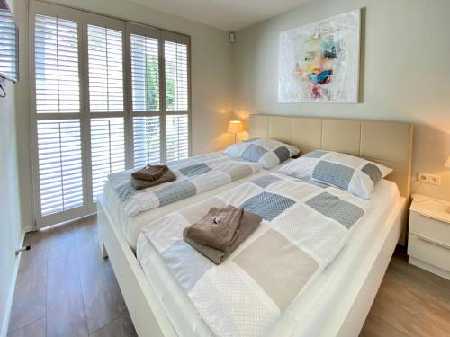 a large bedroom with two beds and two windows at Ferienhaus am Lotsenstieg 6 in Karlshagen