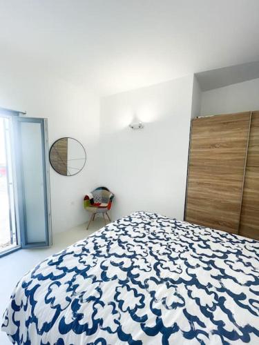 a bedroom with a bed with a blue and white blanket at Aggelos Apartment Central in Antiparos in Andiparos