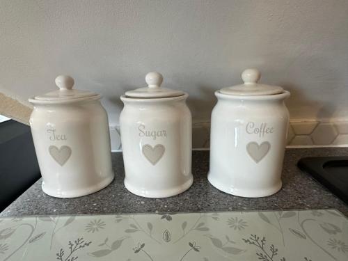 three white jars on a counter with hearts on them at ElMurrs in Bournemouth