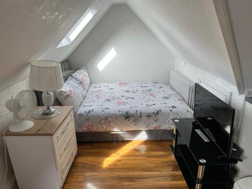 um pequeno quarto no sótão com uma cama e uma cómoda em ElMurrs em Bournemouth