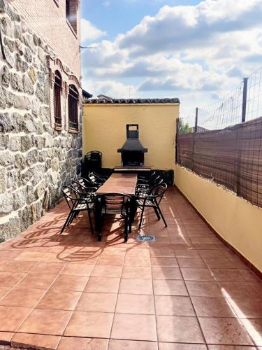 a patio with a table and chairs and a grill at Spacious house in Cenicientos with mountain view in Cenicientos