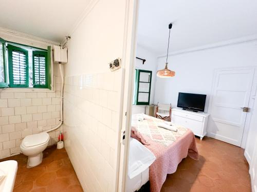baño con cama, aseo y TV en Wonderful House on the beach, en Caldes d'Estrac